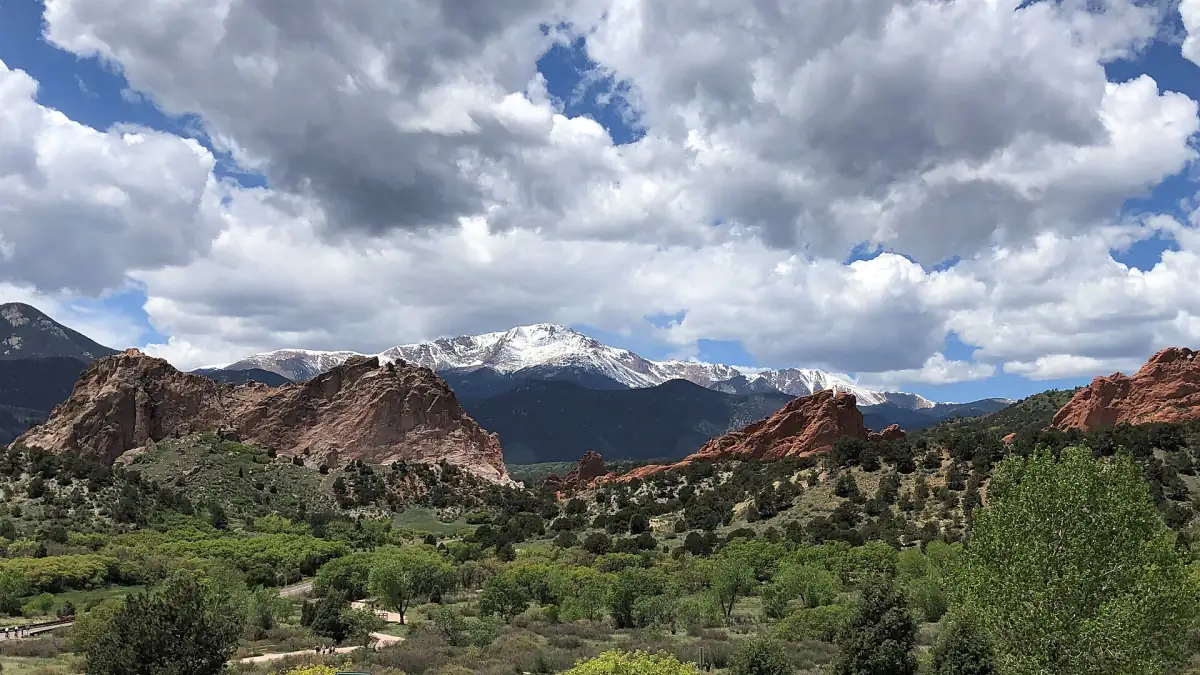 Green summer vegetation around the rocks of Garden of the Gods under a cloudy sky