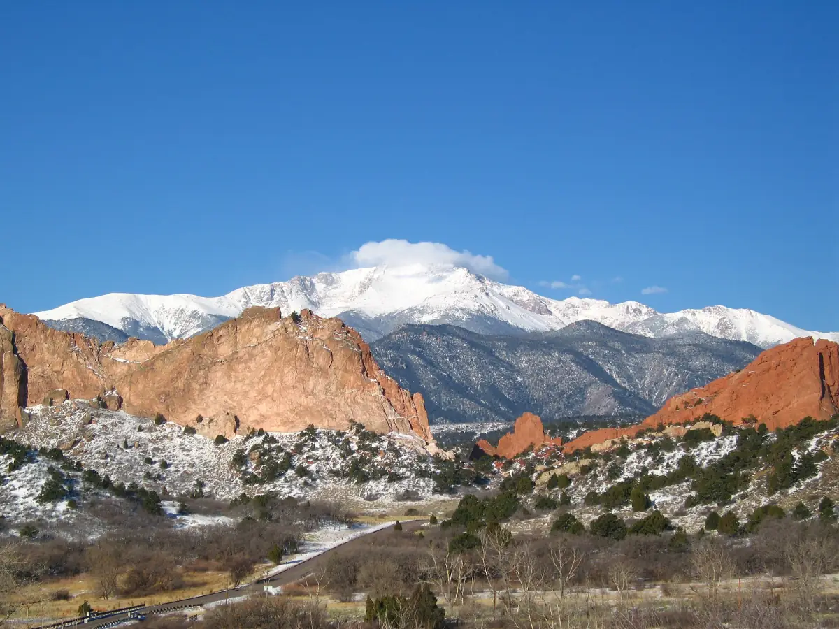 Snow-covered Pikes Peak rising behind the red rocks of Garden of the Gods